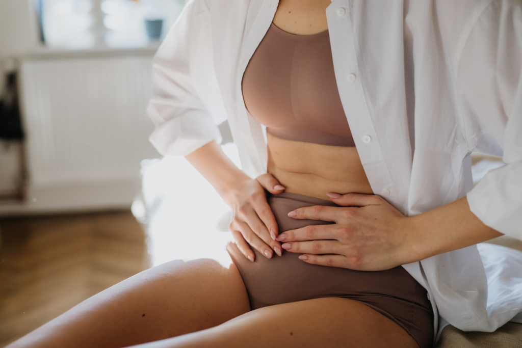 Lady painfully feeling her stomach.