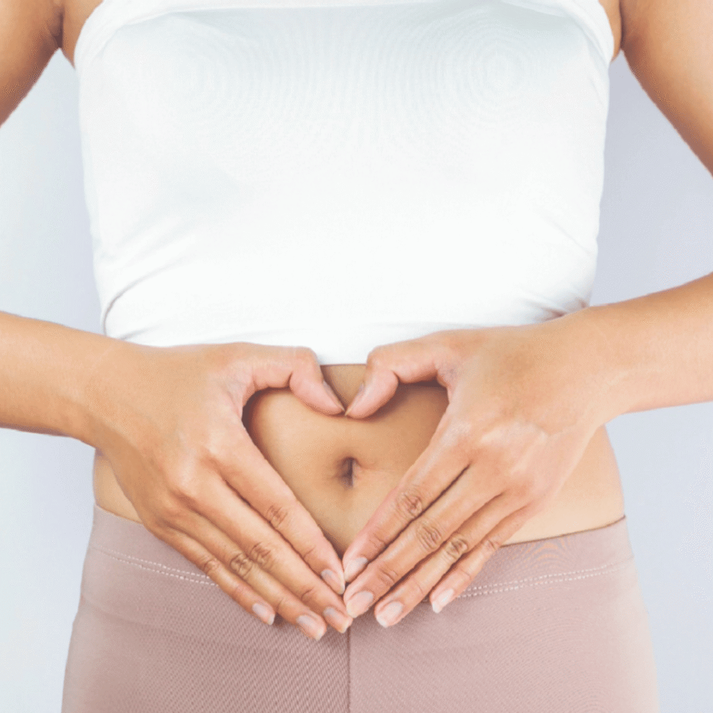 Lady forming a heart shape with hands around pelvic section.